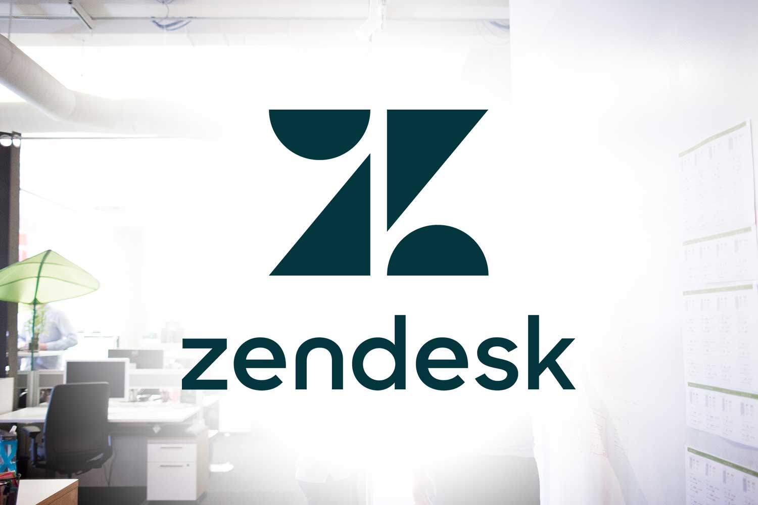 dark green Zendesk Z logo and Zendesk text faded out white into office setting