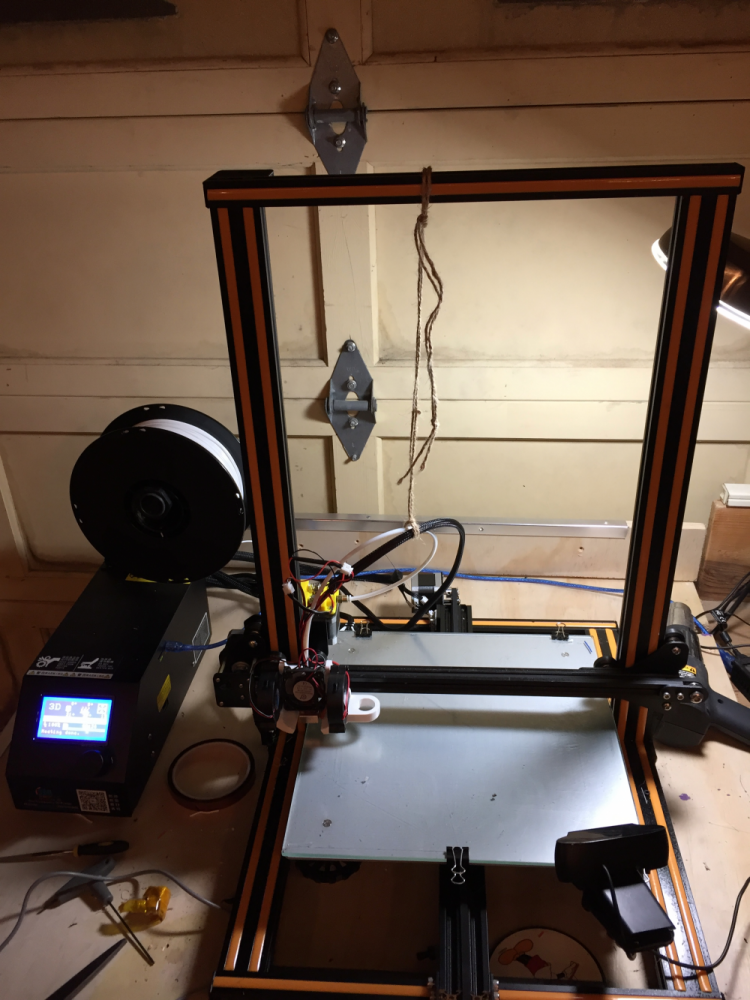 black yellow and red 3D printer partially set up in a garage