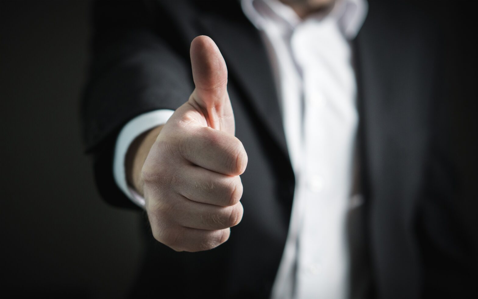 man in suit giving a thumbs up