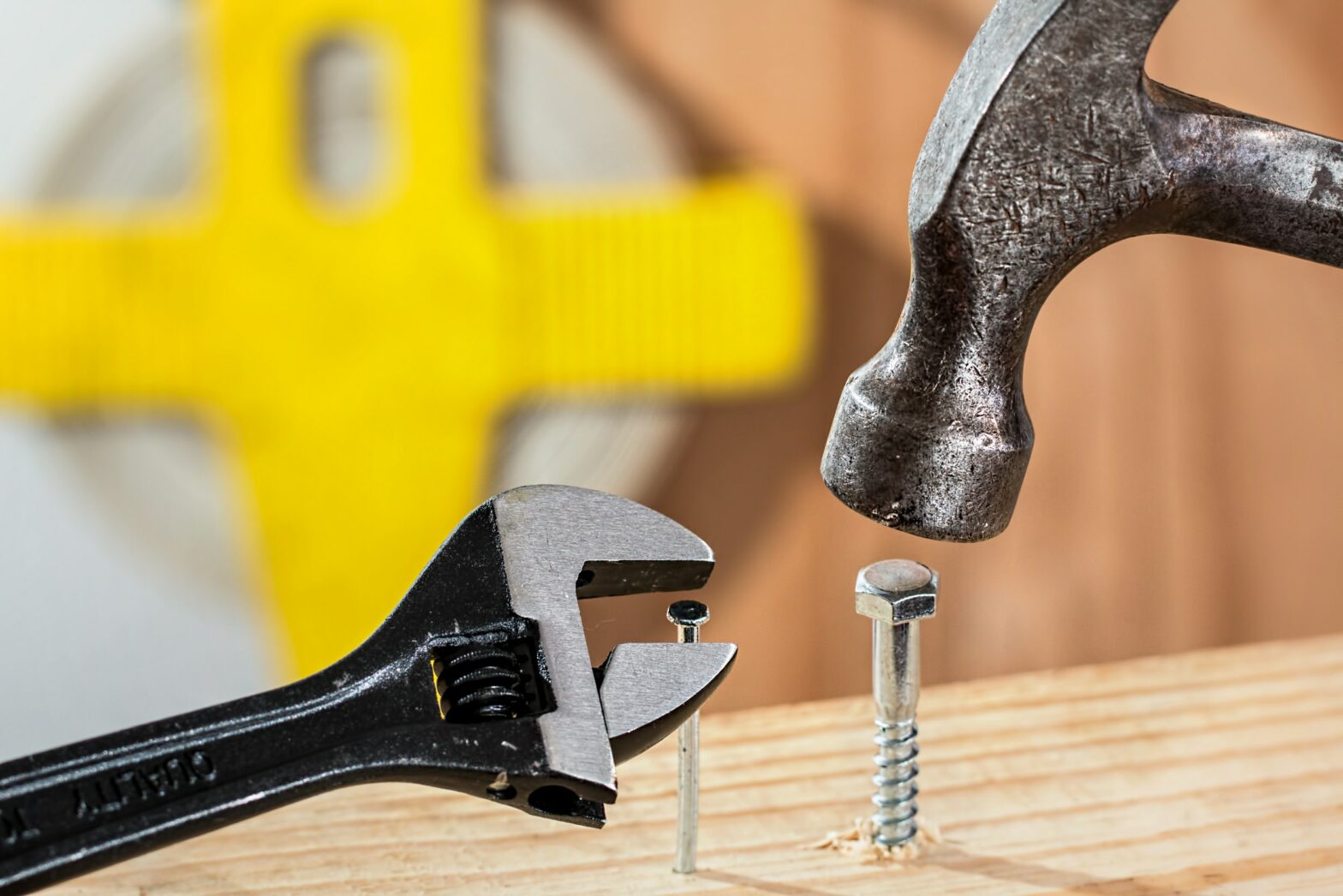 hammer pounding screw and wrench pulling nail