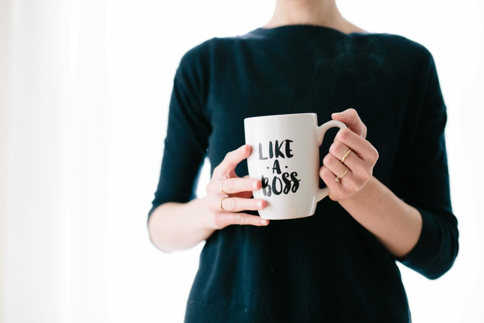 woman holding cup that says like a boss