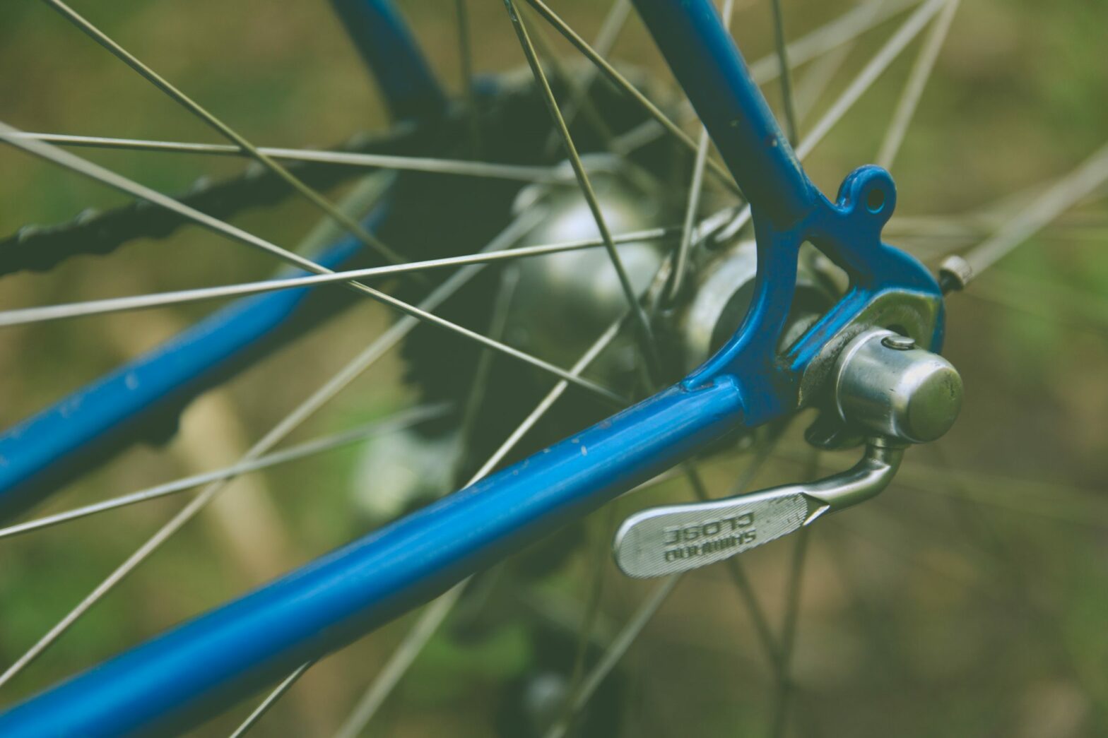 blue bike and silver spokes close up