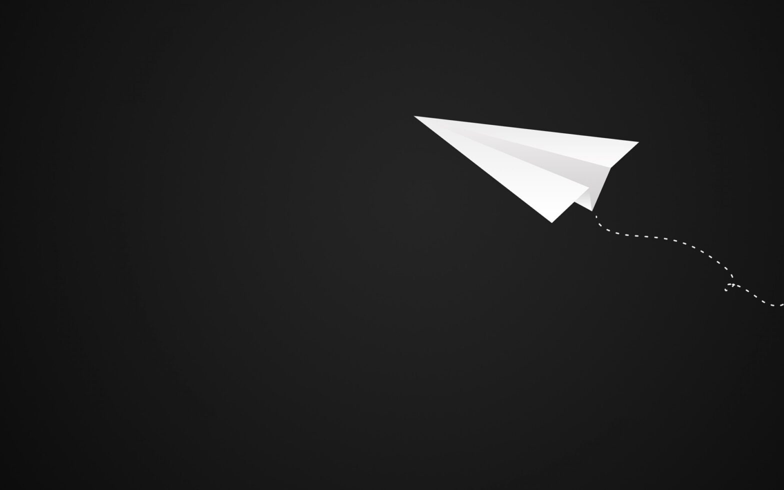 white paper airplane on black background