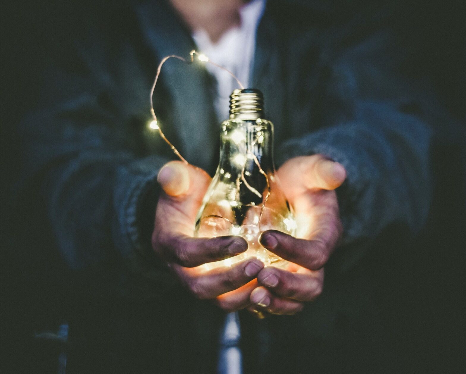 Man holding Light Bulb with dirty hands